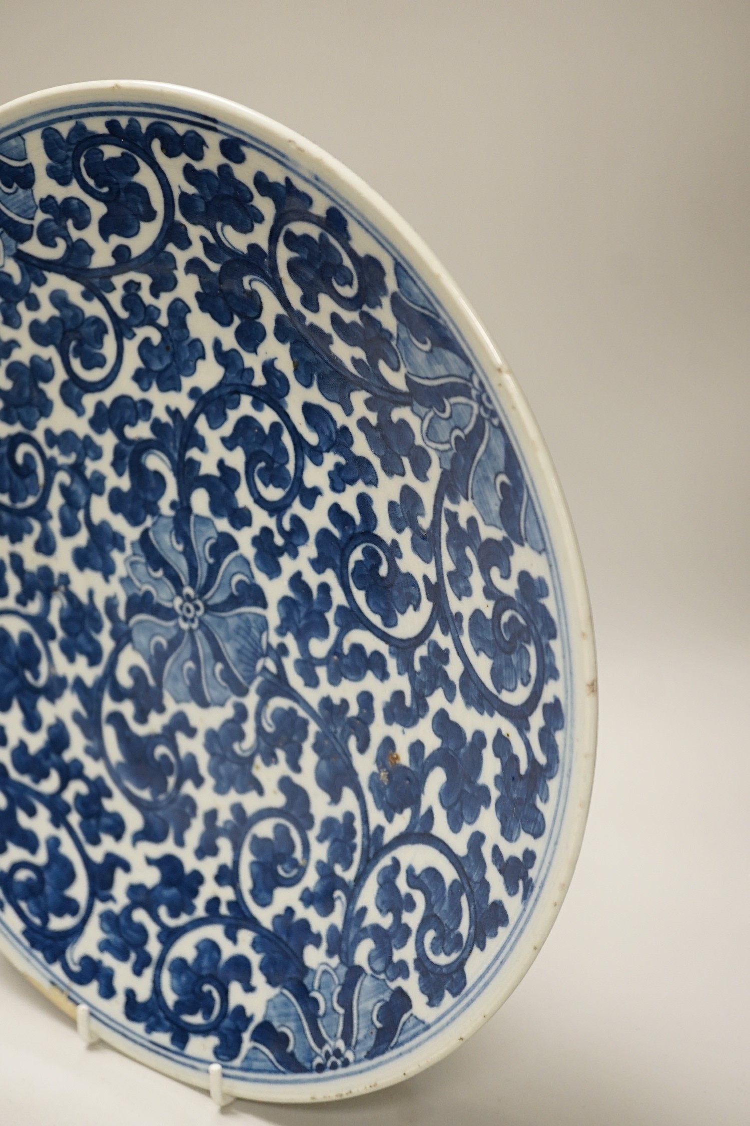 A Chinese blue and white ‘lotus’ charger, together with a bowl and dragon pot on tripod base